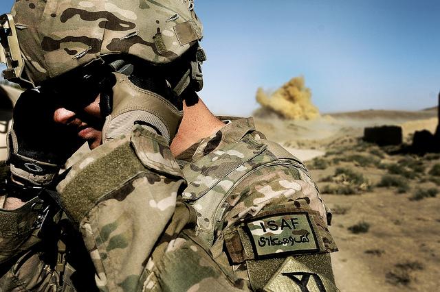 U.S. Army Pfc. Richard Mills, Security Forces rifleman attached to Provincial Reconstruction Team Zabul, secures his eyes and ears as Afghan National Army soldiers conduct a controlled detonation of a Taliban-planted improvised explosive device found on a road in Shinkai, Afghanistan, Oct. 8. ANA soldiers detonated the IEDs after being trained by PRT Zabul on proper controlled detonation techniques. Mills is deployed from Charlie Company, 182nd Infantry Division, Massachusetts National Guard.